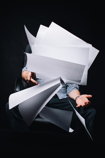 Photo of person throwing blank sheets of paper