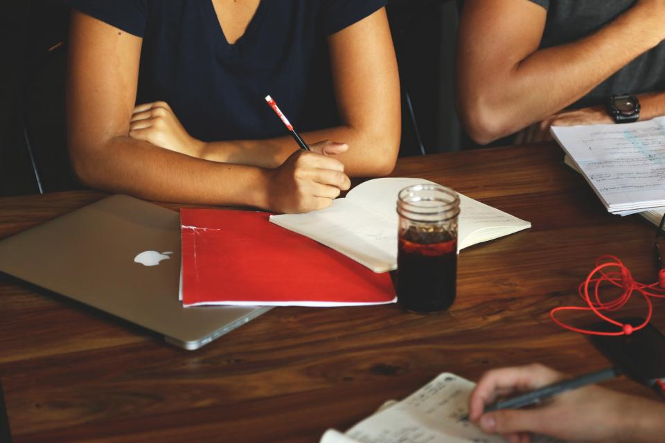 Studious professional group taking notes at desk