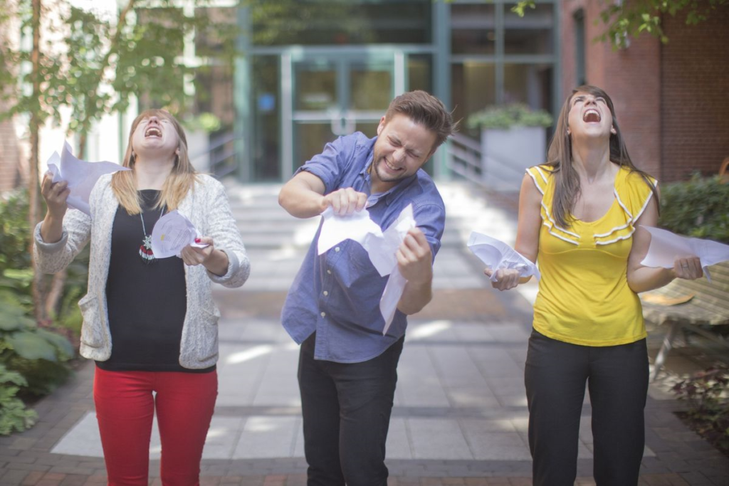 Three people ripping paper up