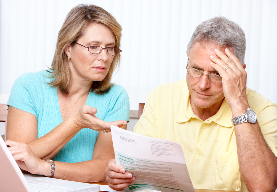 Photo of senior couple planning their retirement with laptop and paper