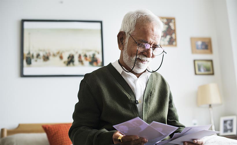 Senior man holding family photos